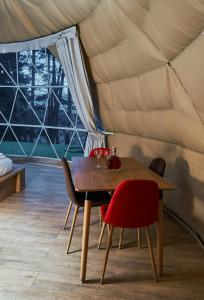 TsalkaDaxvalley Glamping的帐篷内的用餐室,配有桌椅