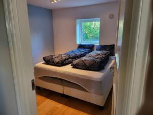卑尔根Nesttunveien appartments的小卧室配有带枕头的床