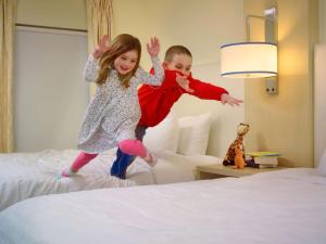 伯灵顿波士顿伯灵顿ES套房圣淘沙集团酒店的男孩和女孩跳上床