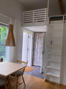 哥德堡Tiny grey house with loft, 15 min from city center的客房设有桌子和高架床。