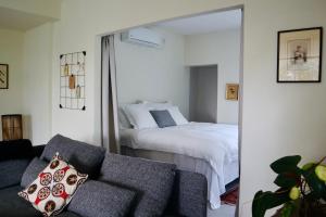 Jaba‘בקתות האס ואטינגר的一间卧室配有一张床、一张沙发和一面镜子