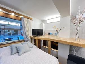 米兰Tra Metropolitana e San Siro, nel Design Elegante, con parcheggio gratuito的一间卧室设有一张床、一台电视和一个窗口。