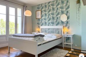 凯恩Le Penthouse - Magnifique Vue - Standing的一间卧室配有一张白色床和热带壁纸