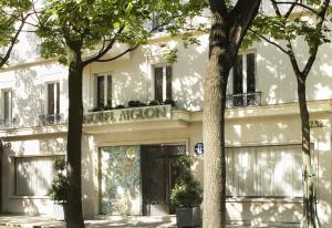 巴黎Hôtel Aiglon的前面有树木的白色建筑