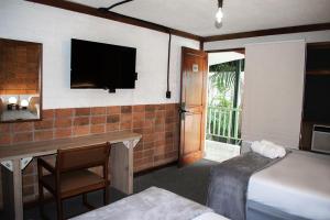 圣何塞Soy Local San José的酒店客房配有一张床、一张书桌和一台电视。
