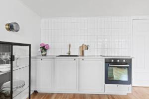 雷克雅未克Central studio apartment的白色的厨房设有水槽和炉灶。