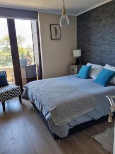 比亚里卡Costanera Playa Villarrica的一间卧室配有一张带蓝色枕头的大床