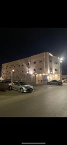 沙鲁拉فندق نوفا بارك的两辆汽车晚上停在大楼前