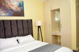 基塔莱Stylish 2 bedroom in Kitale Fully Furnished at 360 Luxury的卧室配有一张床,墙上挂有绘画作品