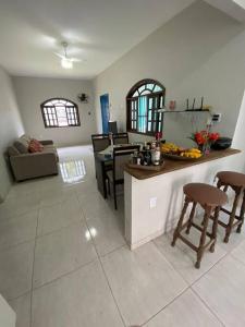 丰当Casa Excelente Praia Grande的厨房以及带桌椅的起居室。