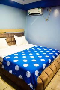 班基Appartement/Studio meublé a Bangui的一张带蓝色和白色的波卡圆毯的床