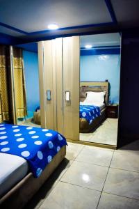 班基Appartement/Studio meublé a Bangui的一间带镜子的卧室和一张位于客房内的床