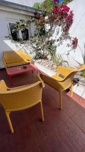 马德普拉塔CASA EN LA FELIZ - pet friendly的庭院里种着鲜花,配有两把椅子和一张桌子