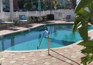 圣徒皮特海滩Oasis Palms Resort的一个带椅子和桌子的大型游泳池