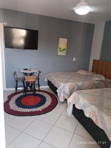 卡达斯诺瓦斯Condominio Residencial Thermas Place的客房设有两张床、一张桌子和一台电视机。