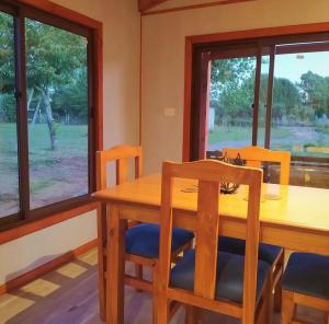 比亚里卡Cabaña Refugio Eluney的一间带木桌和椅子的用餐室