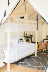 甘特斯维尔Deluxe Glamping Tents at Lake Guntersville State Park的客房内的双层床,配有白色双层床