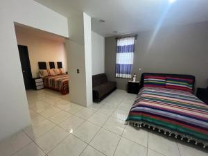 瓦哈卡市Alojamientos OHANA的一间卧室配有一张床和一个沙发