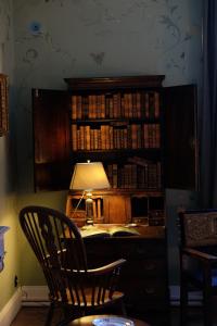 RivarennesChâteau de La Tour en Brenne的一张带台灯的桌子和一个带书籍的书架