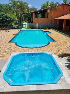 迈林克Chacara Dois Lagos - Mairinque的后院的大型游泳池,设有石头庭院