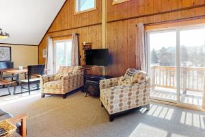 艾恩伍德Alpine Horn Lodge at Big Powderhorn Mountain - Unit A的客厅配有2把椅子和平面电视