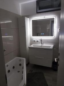 提比里亚4bdrm - 110mr - Dream vacation apartment的一间带水槽和浴缸的浴室以及窗户。