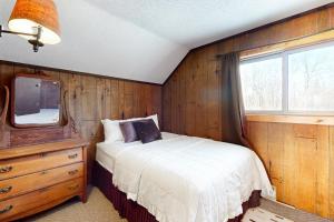 艾恩伍德Alpine Horn Lodge at Big Powderhorn Mountain - Unit A的一间卧室配有一张床,墙上配有电视