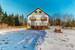 艾恩伍德Alpine Horn Lodge at Big Powderhorn Mountain - Unit C的田野上的房子,地面上积雪