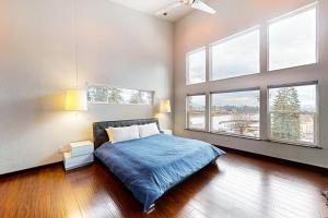 科达伦Spokane River Retreat的一间卧室配有一张带蓝色床单和窗户的床。