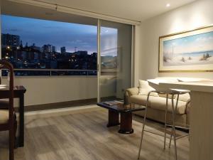 马尼萨莱斯Confortable apartamento的带沙发和大窗户的客厅