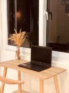 富国Stella's Home的坐在窗前木桌旁的笔记本电脑