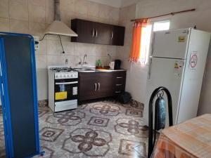 圣奥古斯汀镇Complejo de Cabañas Las Mellizas的厨房配有白色冰箱和炉灶。