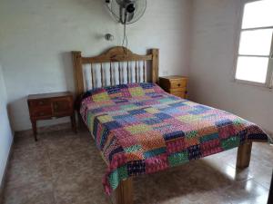 圣奥古斯汀镇Complejo de Cabañas Las Mellizas的一间卧室配有一张带五颜六色被子的床