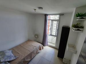 SalsipuedesCute apartment 5min from the airport的一间卧室设有一张床和一个大窗户