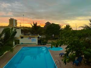 阿塔卡梅斯Hostal La Tolita的一座游泳池,位于一座享有日落美景的房屋前