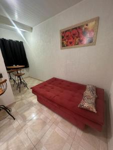 萨夸雷马Residência Grafite的客厅里一张红色的沙发,配有桌子