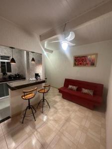 萨夸雷马Residência Grafite的一间带红色沙发的客厅和一间厨房