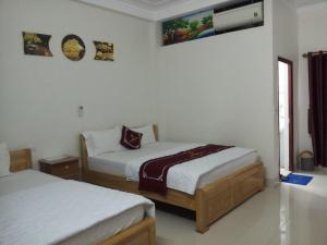 Lục Ngạnhằng hiên hotel的一间卧室设有两张床,墙上配有电视。