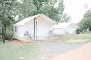 甘特斯维尔Luxury Glamping Tents @ Lake Guntersville State Park的大型白色帐篷,带椅子