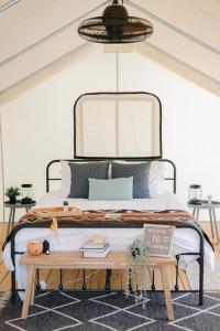 甘特斯维尔Luxury Glamping Tents @ Lake Guntersville State Park的一间卧室配有一张床和一张桌子及书籍