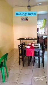 哥打京那巴鲁Samma HomeStay Double Storey Terrace House的一个带红色桌子和椅子的用餐区