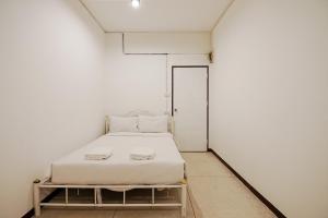 GodownGO INN Asiatique The Riverfront - Charoen Krung โกอินน์ เอเซียทีค เจริญกรุง的一间白色的小房间,里面设有一张床