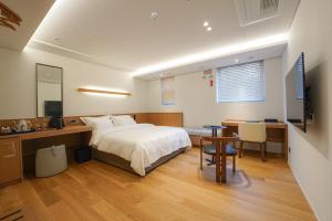 釜山Hotel Ground27的一间卧室配有一张床、一张桌子和一张桌子