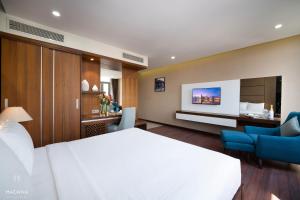 岘港Hadana Boutique Hotel的酒店客房,配有一张床、一张桌子和椅子