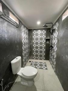 卡朗阿森Oemah Gebagan 78 Pertiwi Room的一间带卫生间和黑色墙壁的浴室