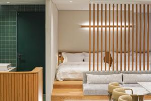 釜山Hotel Ground27的一间卧室配有一张床,客厅配有沙发