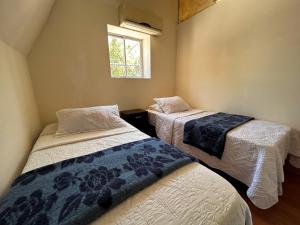 圣地亚哥Chez Humbert的带窗户的客房内的两张床