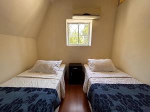 圣地亚哥Chez Humbert的小型客房 - 带2张床和窗户