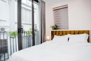 河内AimeeHouse - Trích Sài的卧室设有白色的床和大窗户