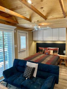 Lake AlfredThe Lake Alfred Citruswood Cabin的一间卧室配有一张床和一张蓝色的沙发